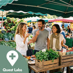 People shopping at an outdoor farmers market with a Quest Labs logo.