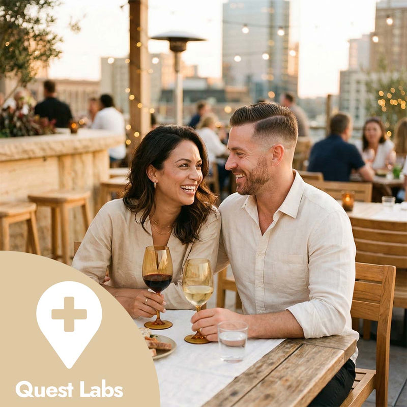 Couple enjoying wine at a rooftop restaurant with cityscape in the background