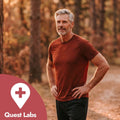 Man in a red shirt standing outdoors with Quest Labs logo in the corner