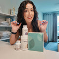 Woman showing Sage's Female Hormone Optimization Kit with Supplement Bottles and Tasso Kit Box.