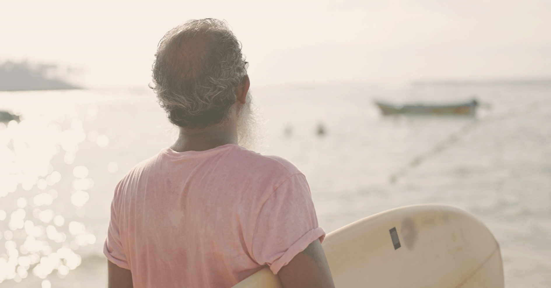 man with surfboard looking at the water | Sage Healthspan