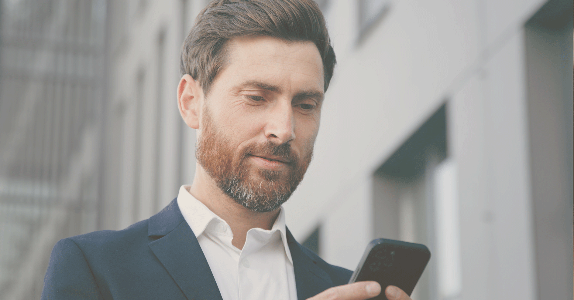 Man in a suit looking at his phone.